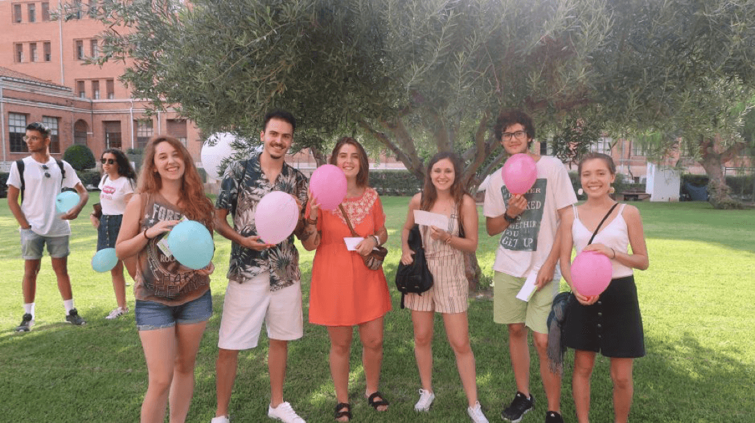 University students holding pink balloons at a Student Mentoring Programme event.