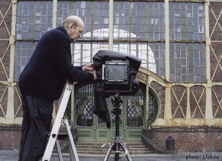 Bernd Becher montando cámara de banco óptico en un paisaje industrial
