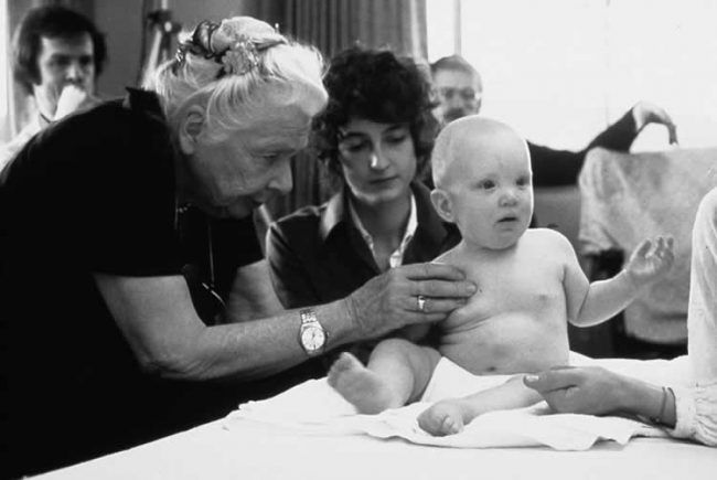 Una imagen elocuente de Fisioterapia y maternidad: la gran Ida Rolf tratando a un bebé en presencia de su madre.