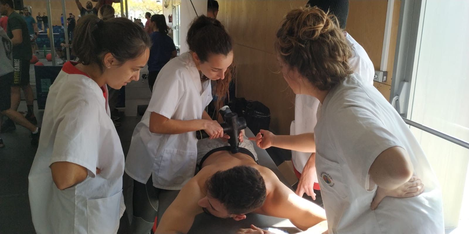 Dando la batalla por el deporte. Estudiantes de Fisioterapia CEU-UCH en la batalla del crossfit de Castellón. En la imagen utilizando una pistola de masaje. 2020.