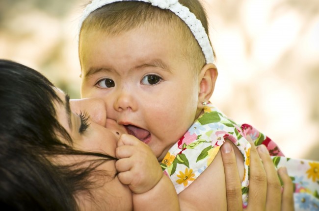 foto de una madre besando a su bebe en la boca
